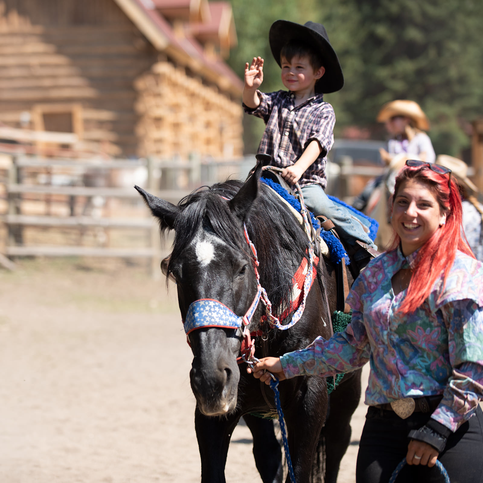 young-rider-1200px Expert staff happily helps small boy on horseback